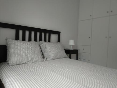 a bedroom with a white bed with two pillows at Athani Summer House (Apartments 01 - 02) in Athanion