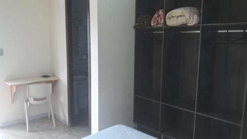 a bedroom with a black shower stall and a table at Hotel Maringa in Maringá