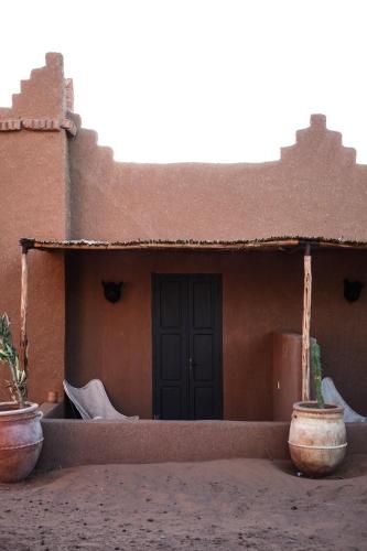 a small house with a door and some pots at Kasbah Aitisfoul in Tagounite