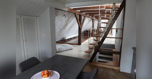 Habitación con mesa y escalera de caracol. en Ferienwohnung Olafs Werkstatt, en Neustadt