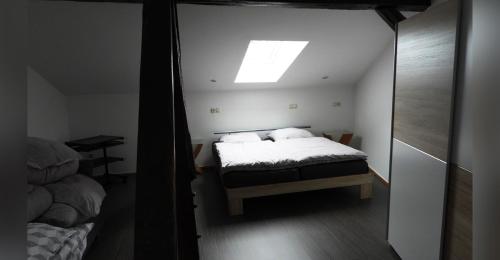 a small bedroom with a bed and a skylight at Ferienwohnung Olafs Werkstatt in Neustadt