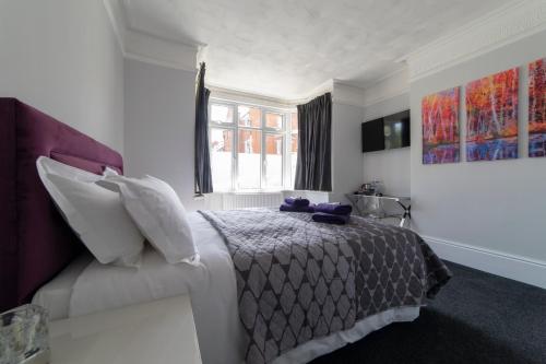 a white bedroom with a bed and a window at The Norna in Cambridge