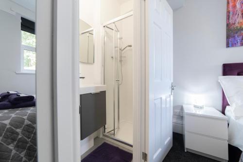 a bathroom with a shower and a bed and a mirror at The Norna in Cambridge