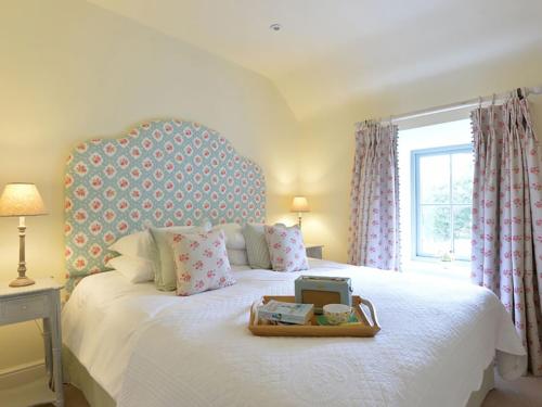 a bedroom with a white bed with a tray on it at Penrhyn Farm in Penrhos-Lligwy