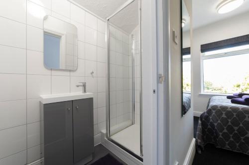 a bathroom with a shower and a sink and a bed at The Norna in Cambridge