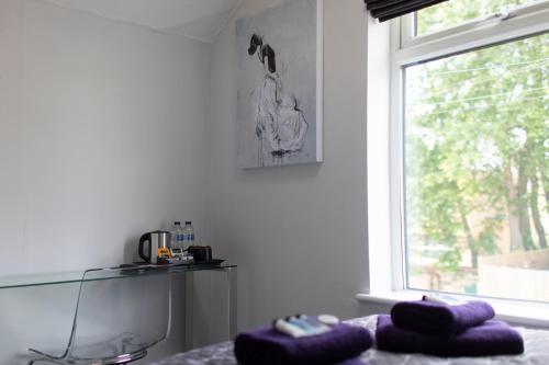 a room with purple pillows on a table and a window at The Norna in Cambridge