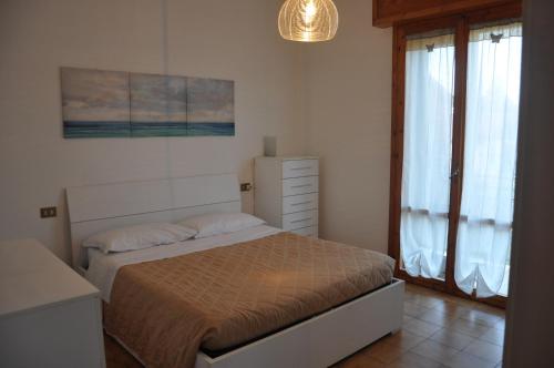 a bedroom with a bed and a dresser and a window at GiaLoSa Biker House in Villa Verucchio