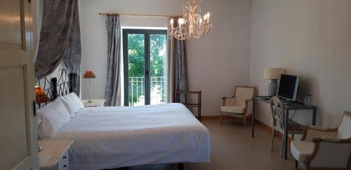 a bedroom with a bed and a chair and a window at Hotel VillaMarcilla in Marcilla