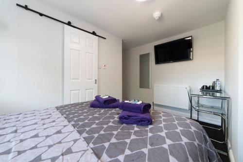 a bedroom with a bed and a tv on the wall at The Norna in Cambridge