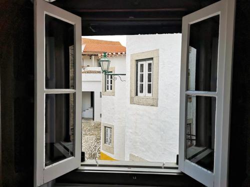an open window with a view of a building at Foral Guest House - Óbidos in Óbidos