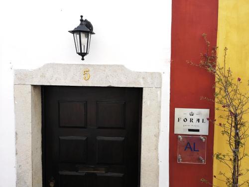 a black door with a light on top of it at Foral Guest House - Óbidos in Óbidos