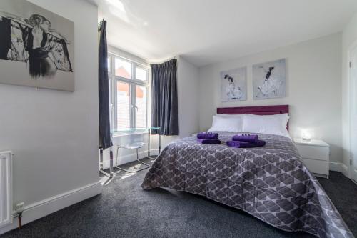 a bedroom with a bed with purple pillows on it at The Norna in Cambridge