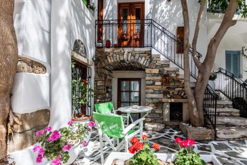 un patio con mesa, sillas y flores en Arco Naxos Luxury Apartments, en Naxos Chora