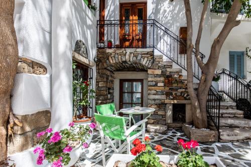 a patio with a table and chairs and flowers at Arco Naxos Luxury Apartments in Naxos Chora