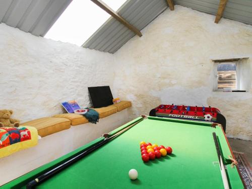 a room with a pool table and a couch at Pentreheulyn in Bodewryd