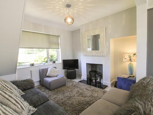 a living room with a couch and a fireplace at Perthi in Morfa Nefyn