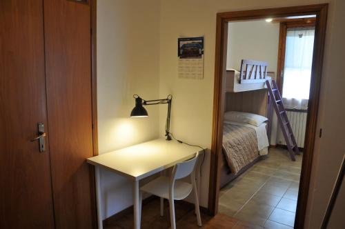 a desk with a lamp and a bed in a room at GiaLoSa Biker House in Villa Verucchio