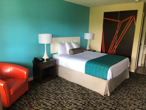 a hotel room with a bed and a red chair at Howard Johnson by Wyndham Rocky Hill in Rocky Hill