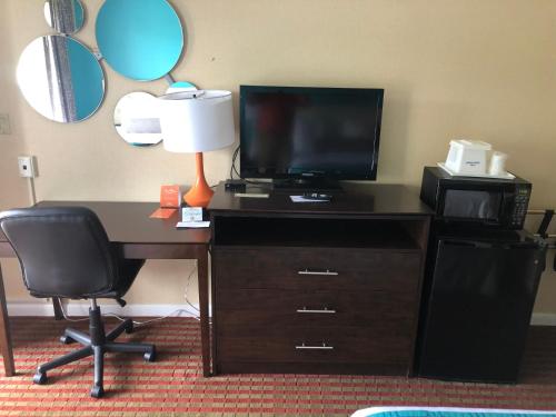 a desk with a television and a desk with a lamp at Howard Johnson by Wyndham Rocky Hill in Rocky Hill