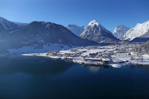 a town on a lake with snow covered mountains at Haus Bauer in Pertisau