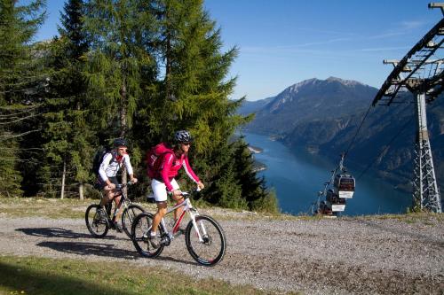 two people riding bikes on a hill with a ski lift at Haus Bauer in Pertisau
