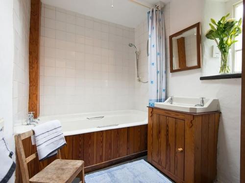 a bathroom with a tub and a sink and a toilet at Pantlleni in Beddgelert