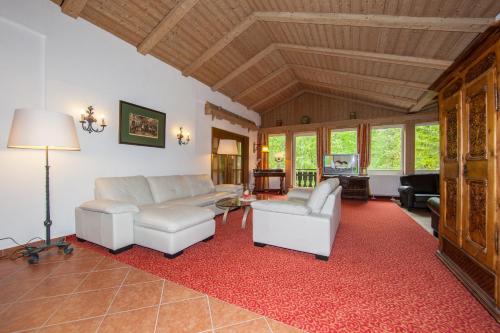 a living room with white furniture and a red rug at Gästehaus Lärchenhang in Mittenwald