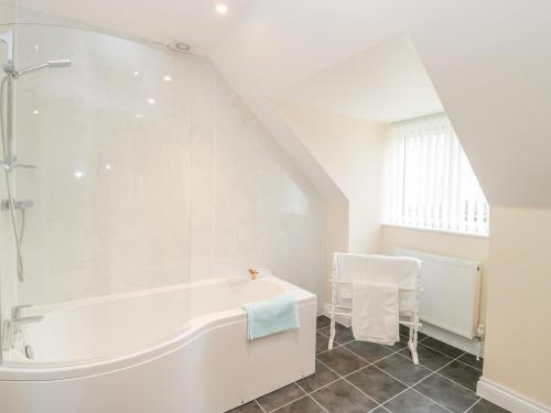 a white bathroom with a tub and a sink at The Donkey Shed in Sherborne