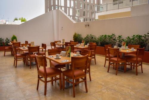 comedor con mesas y sillas de madera en Hotel RRU Puebla, en Puebla