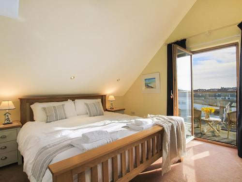 a bedroom with a large bed and a large window at Penmynydd in Trearddur