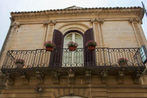 a balcony with potted plants on a building at Residenza Donnafugata B&B in Ragusa