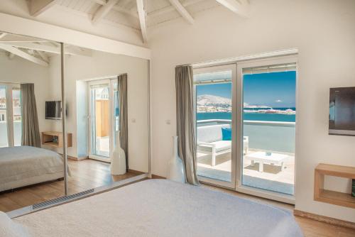 een slaapkamer met een bed en uitzicht op de oceaan bij Sideratos Sea View City Apartment in Chios