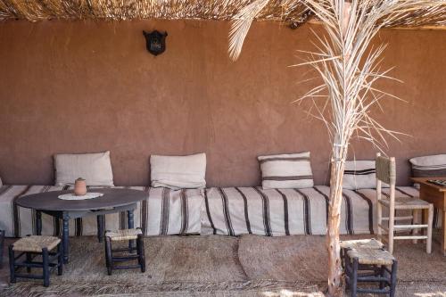 a room with a couch and a table and chairs at Kasbah Aitisfoul in Tagounite