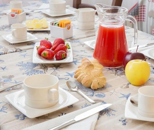 a table with plates of fruit and a pitcher of juice at Edomat in Monserrato