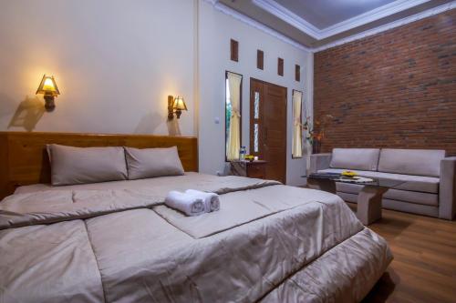 a bedroom with a large bed with a towel on it at Maher House Borobudur in Magelang