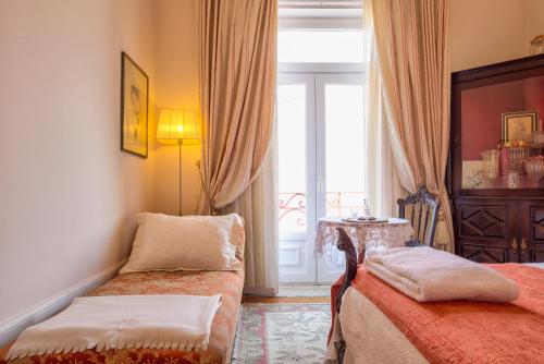 コインブラにあるAdore Portugal Coimbra Guest Houseのベッド2台と窓が備わるホテルルームです。