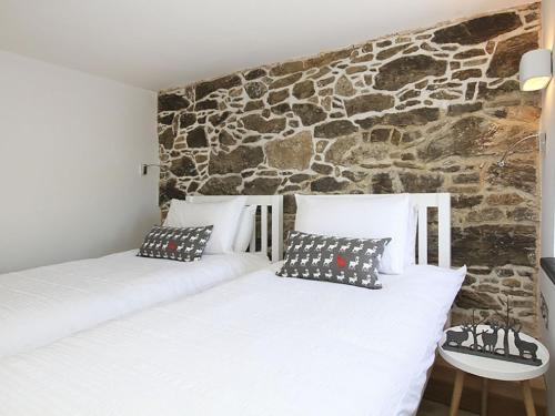 duas camas num quarto com uma parede de pedra em Rhyd Angharad Barns em Llanrhyddlad