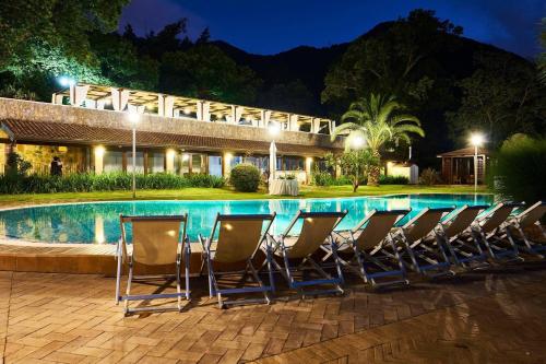a group of chairs next to a pool at night at Villapiana Country House in Pellezzano