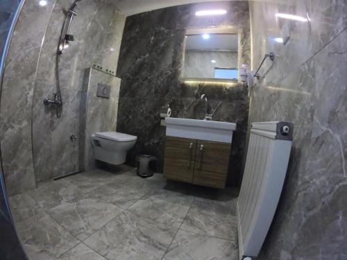 a bathroom with a sink and a toilet and a shower at Belen Yayla Otel in Aybastı