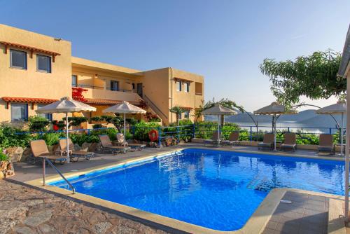 una piscina in un hotel con sedie e ombrelloni di Elounda Heights (Adults Only) a Eloúnda