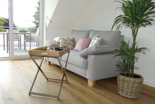 a living room with a couch and a table with two plants at Weingut Endesfelder in Mehring