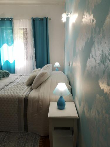 a bedroom with a bed and a table with a lamp at Nature Guesthouse in Lagos