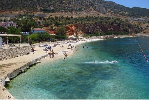 a beach with a bunch of people in the water at Enda Boutique Hotel Kalkan in Kalkan