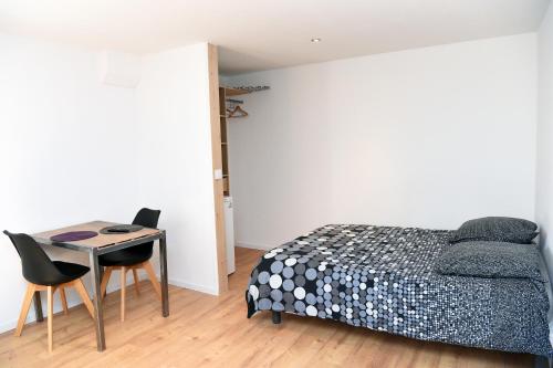 a bedroom with a bed and a table and chairs at STUDIO RIGAUD in Montpellier