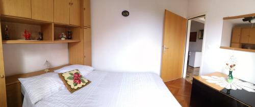 a bedroom with a white bed with a pillow on it at Naomi's Sunshine in Cres