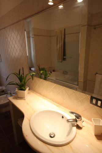 a bathroom with a sink and a mirror over a counter at Porta del Vento in Giardini Naxos