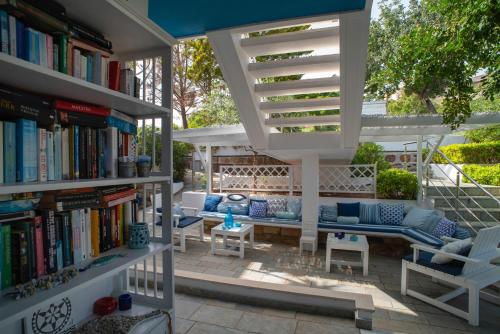 een patio met boekenplanken en een bank en stoelen bij Sideratos Apartments in Karfás