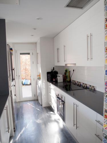 a kitchen with white cabinets and a black counter top at Casa David in Las Negras