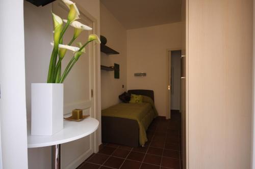 a room with a bed and a vase with flowers at Porta del Vento in Giardini Naxos
