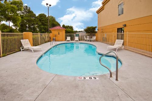 une petite piscine avec des chaises et une clôture dans l'établissement La Quinta Inn by Wyndham Decatur Alabama, à Decatur
